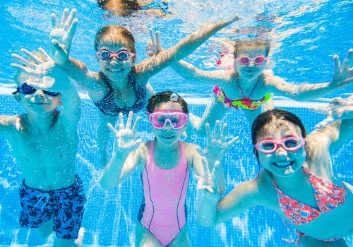 little kids swimming  in pool  underwater.